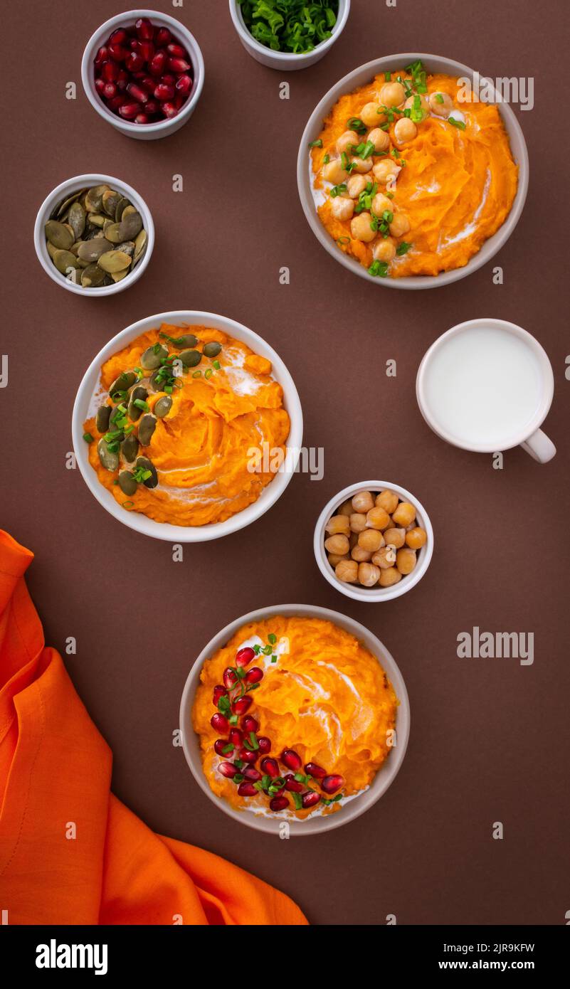Pumpkin puree soup of butternut squash in bowls with chickpeas and