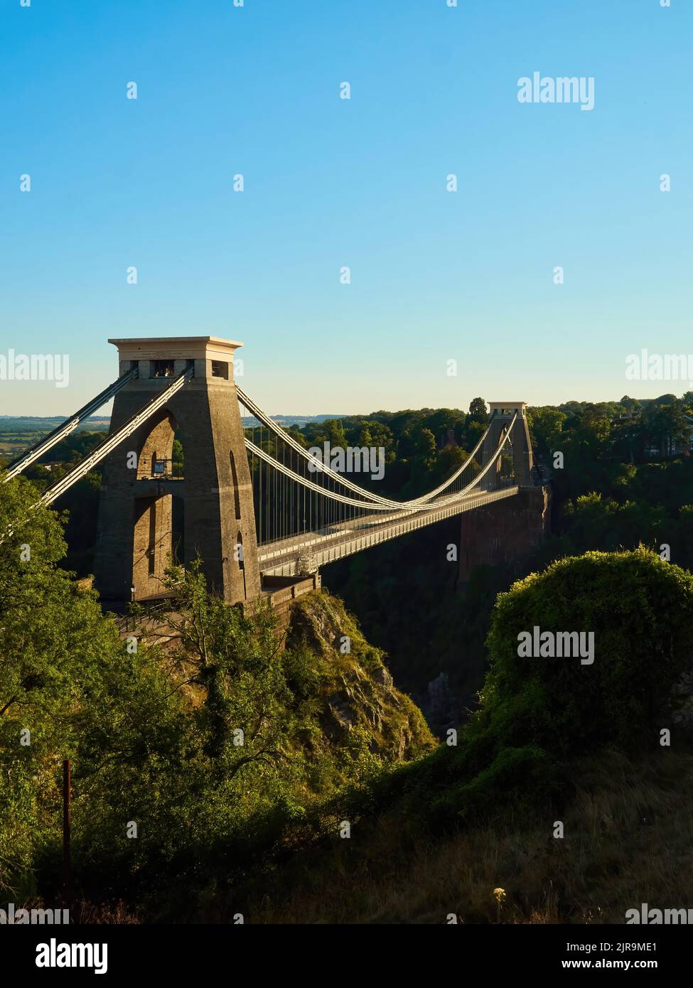The famous Clifton Suspension Bridge at Bristol in dramatic side-lighting from a setting summer sun. Stock Photo