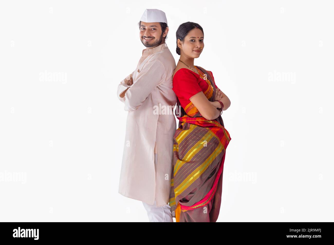 Portrait of Maharashtrian couple standing back to back against white background Stock Photo