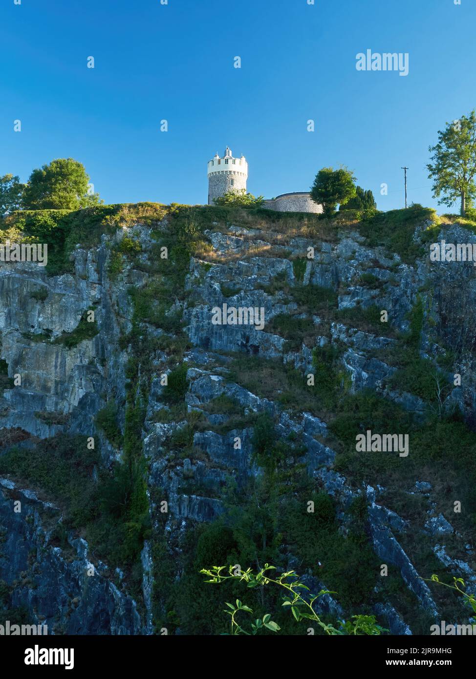 The famous Clifton Observatory, perched on a striated clifftop and balanced on the edge between warm, bright, slanting sunlight and cool shade. Stock Photo