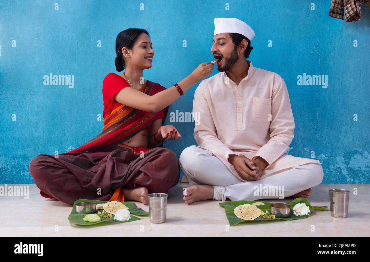 Maharashtrian woman feeding her husband during lunch Stock Photo