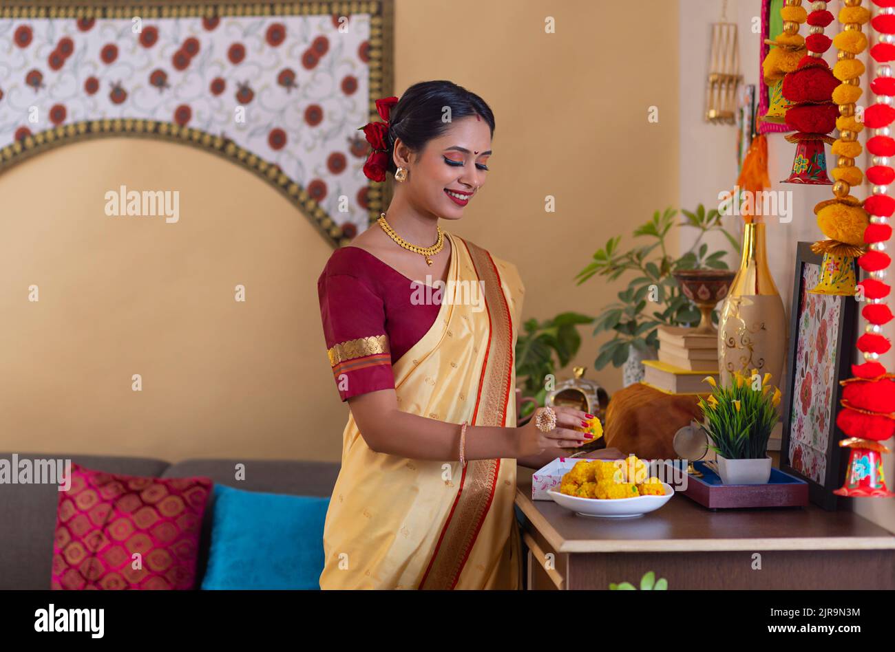 Portrait of a Maharashtrian woman in traditional outfit standing with ladoo Stock Photo