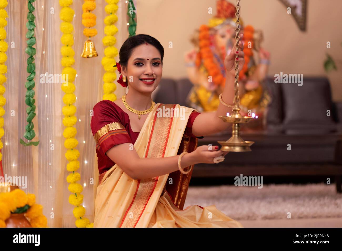Portrait of Maharashtrian woman in traditional dress holding oil lamp on the occasion of Ganesh Chaturthi Stock Photo
