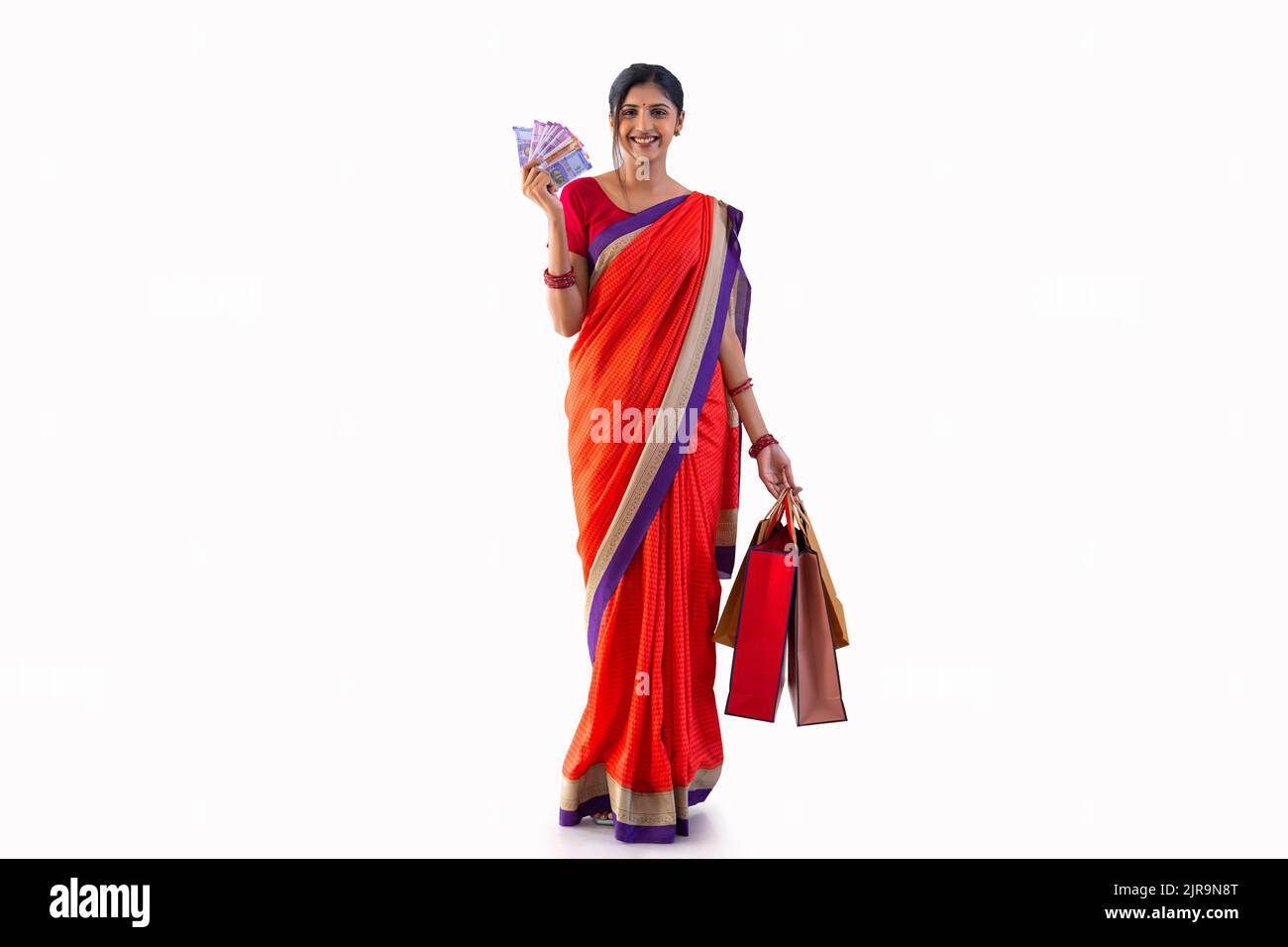 Portrait of young cheerful woman with shopping bags and Indian Currency Stock Photo