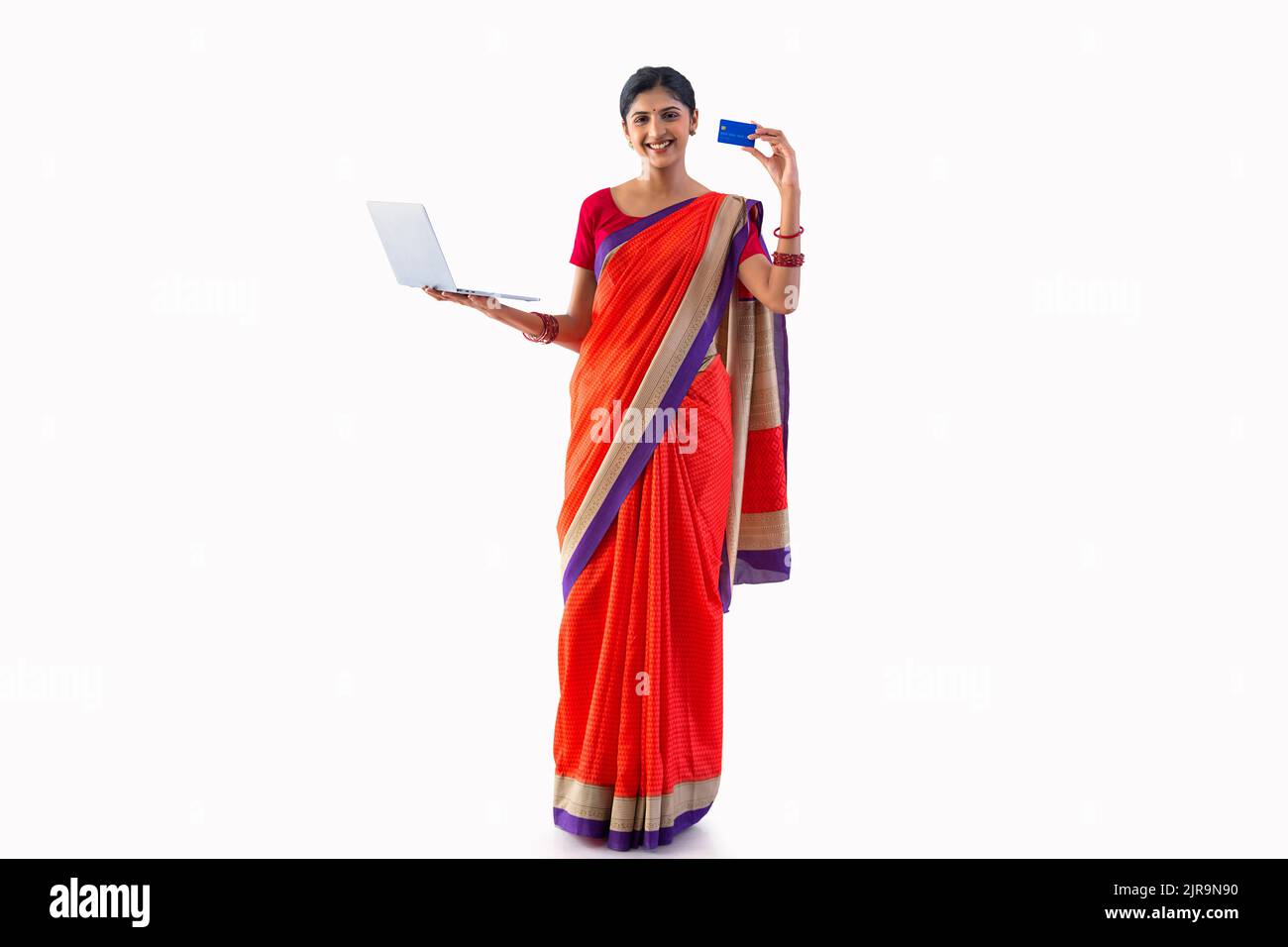 Portrait of a young woman holding laptop and showing credit card Stock Photo