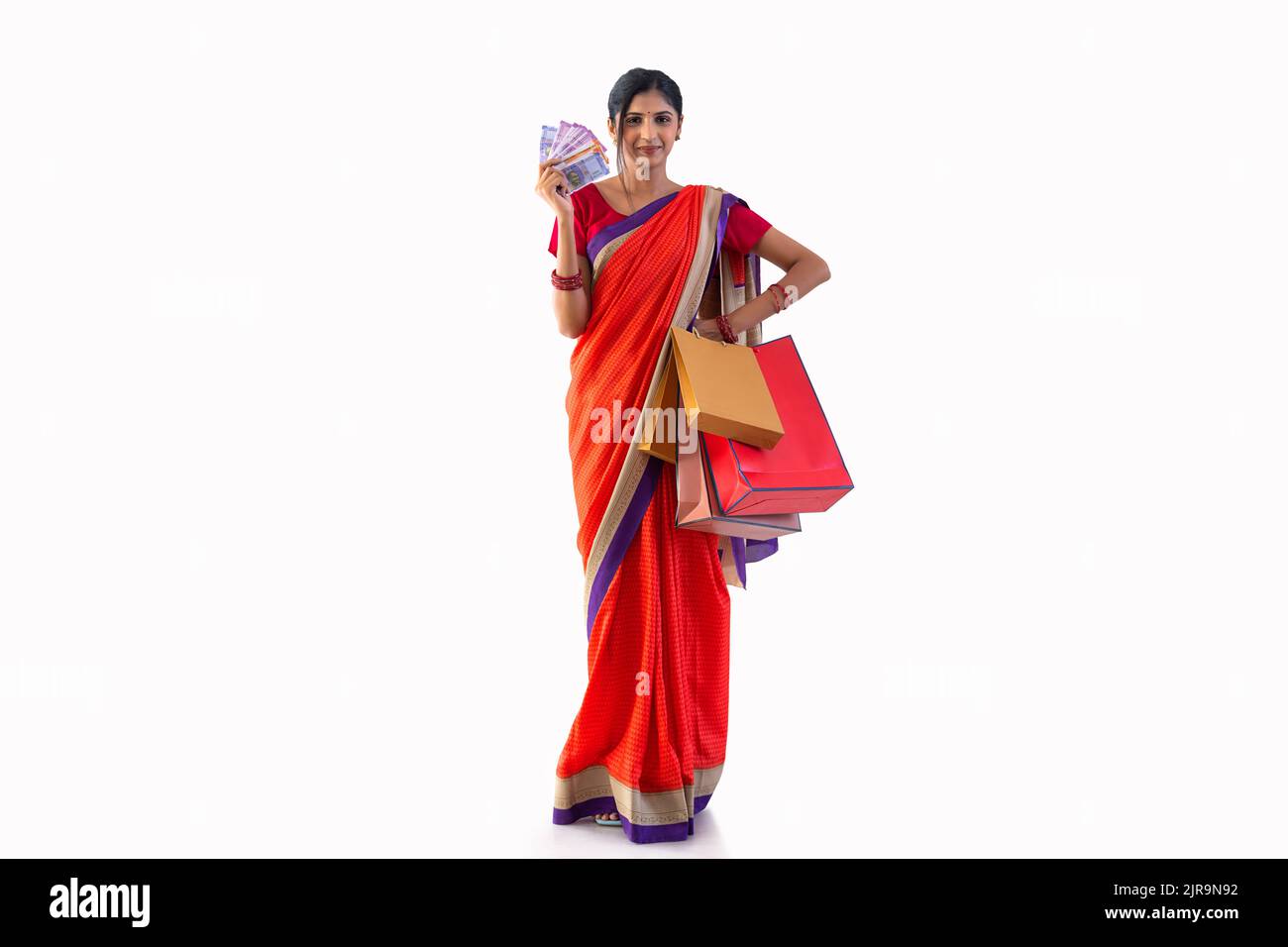 Portrait of young cheerful woman with shopping bags and Indian Currency Stock Photo