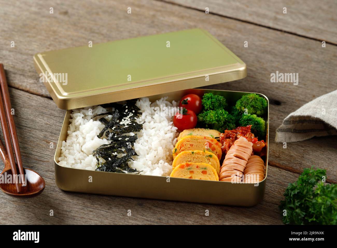 https://c8.alamy.com/comp/2JR9NXK/dosirak-korean-lunch-box-contain-steamed-rice-with-gyeranmari-sausage-kimchi-tomato-and-steamed-broccoli-on-wooden-table-2JR9NXK.jpg