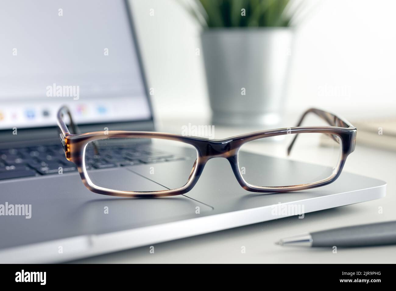 Close up of Eyeglasses on modern laptop on desk. Eye health and vision