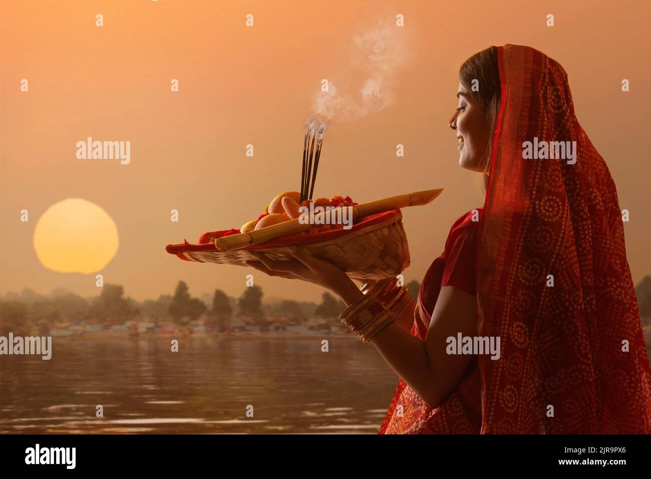 woman from Bihar offers prayers to the sun in the early morning hours woman from Bihar offers prayers to the sun in the early morning hours