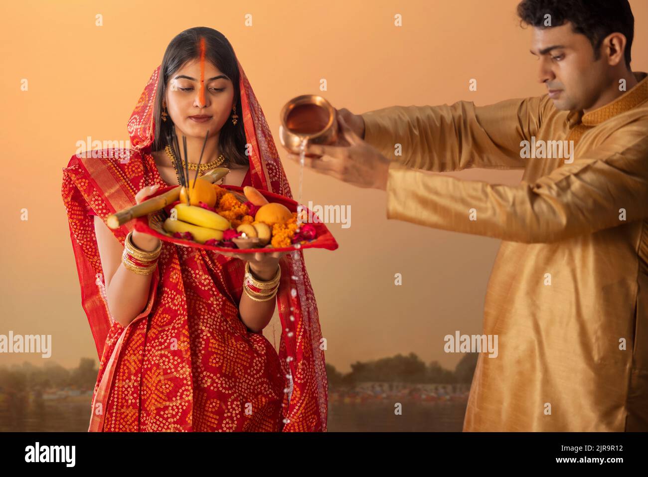 Couple from Bihar offers prayers to the  sun  in the  early morning hours during  Chhath Puja festival Stock Photo