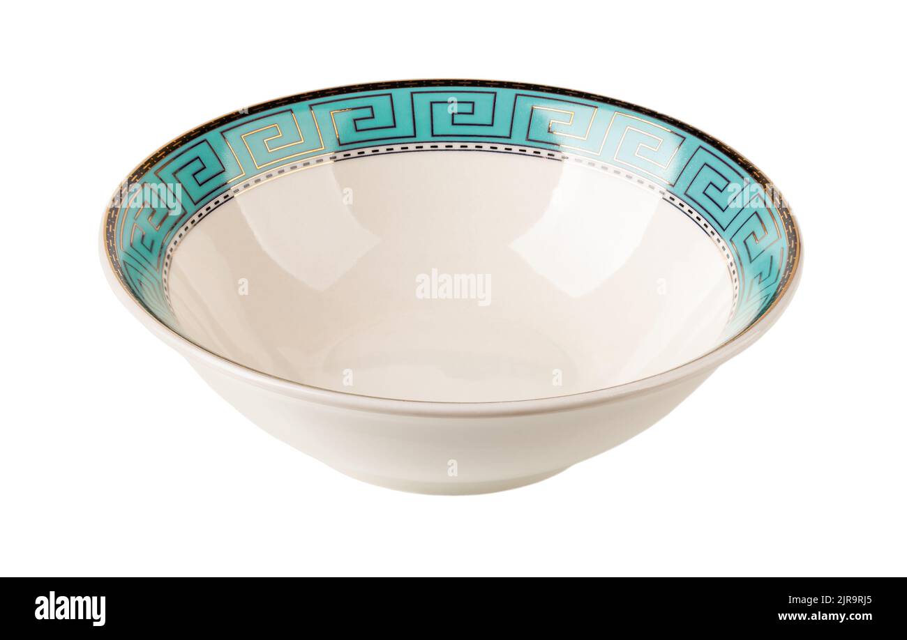 White deep dish with turquoise border cutout. Porcelain bowl decorated with a golden meander ornament on a blue border. Empty crockery isolated. Stock Photo