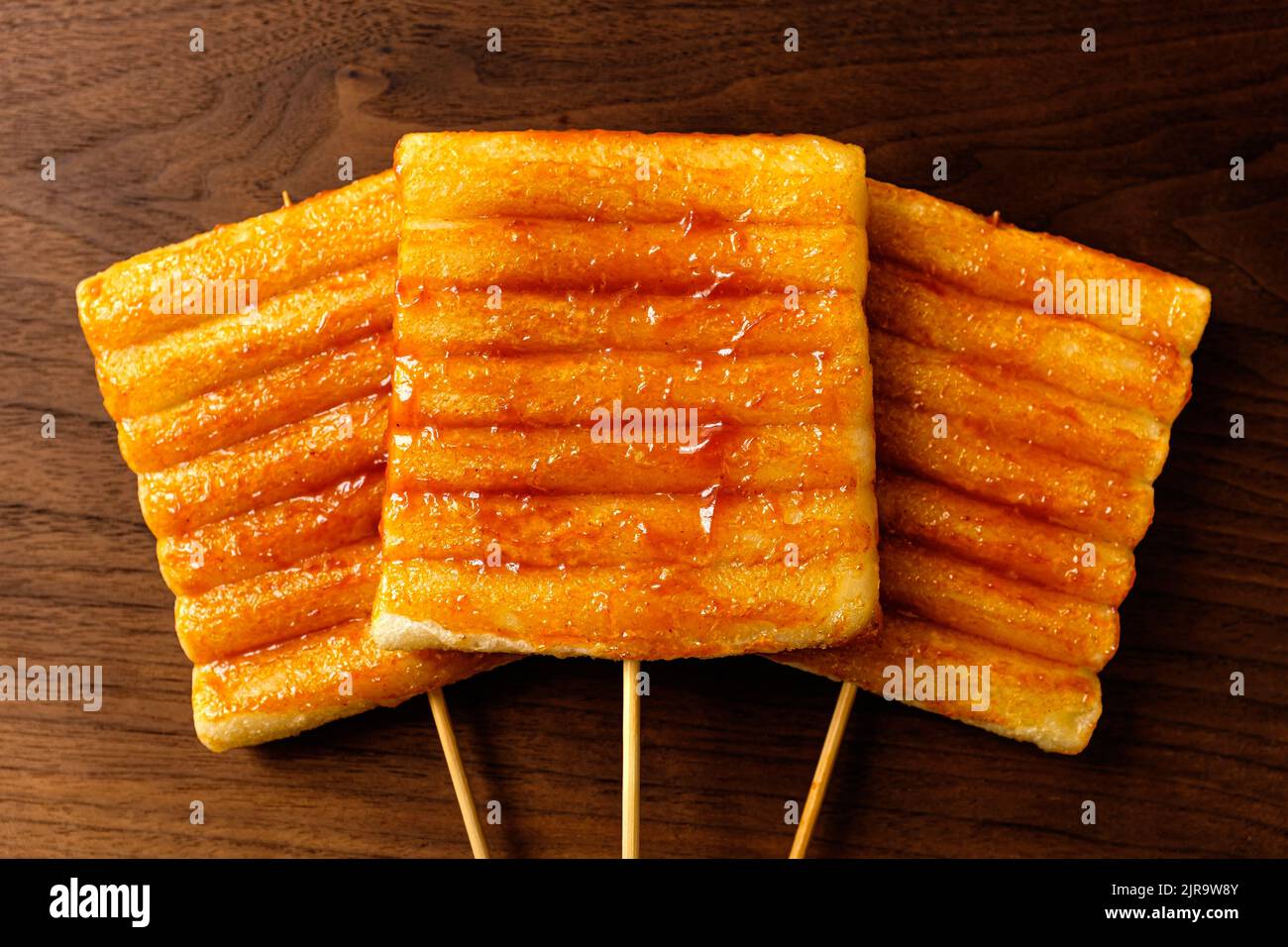 Korean food culture. A dish of fried rice cakes on a skewer. Food seasoned with red pepper paste Stock Photo
