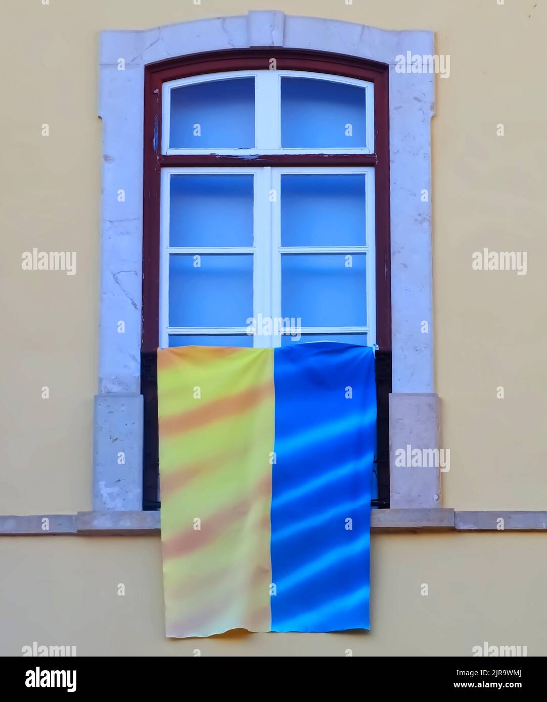 Ukrainian flag hangs on a window to show solidarity Stock Photo Alamy