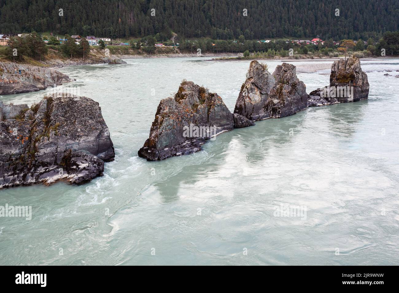River With Large Rocks A fast-flowing wide and full-flowing mountain river. Large rocks stick ...