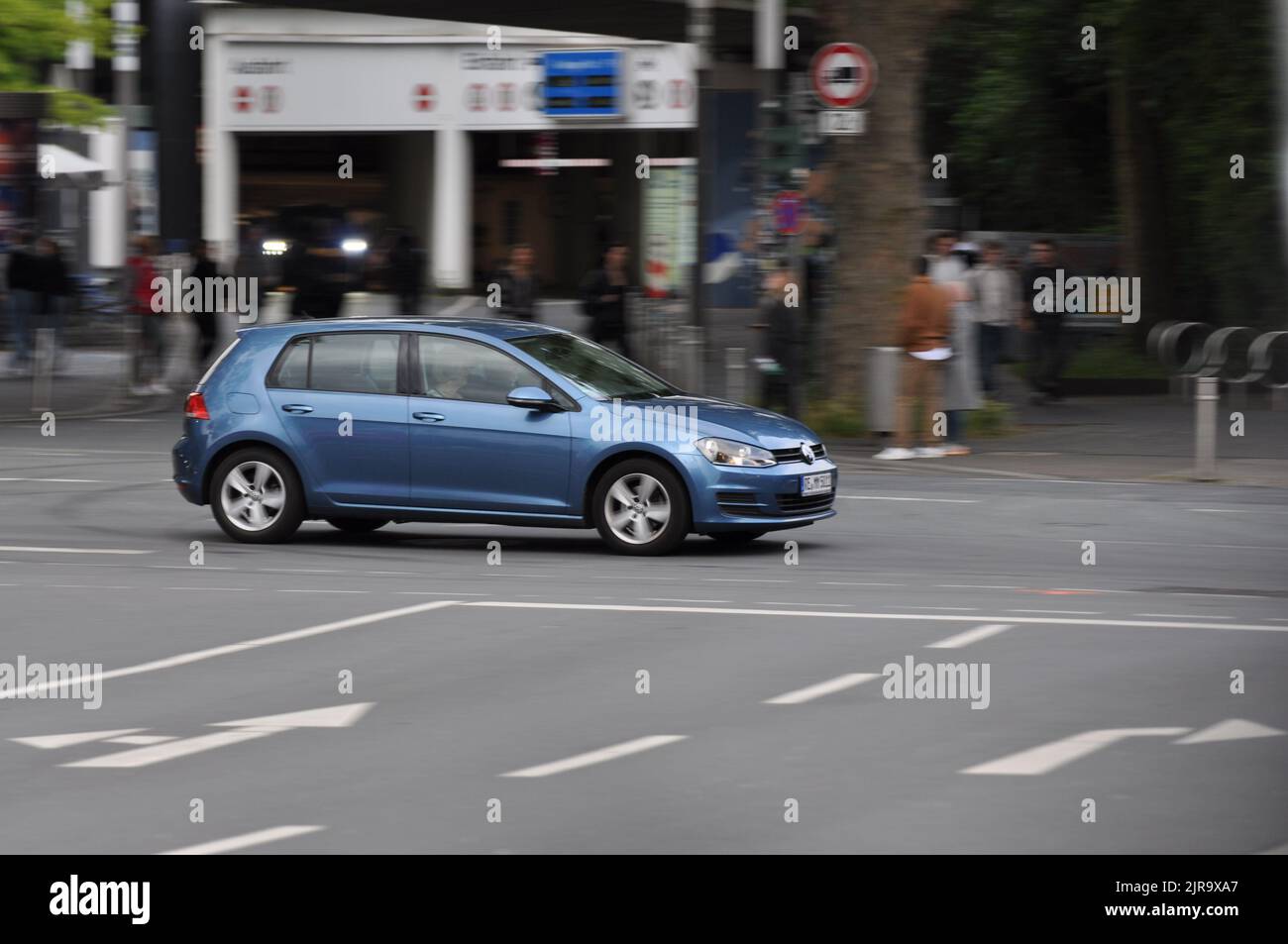 A blue VW Golf VII while driving on intersection in Bochum, Germany. Stock Photo