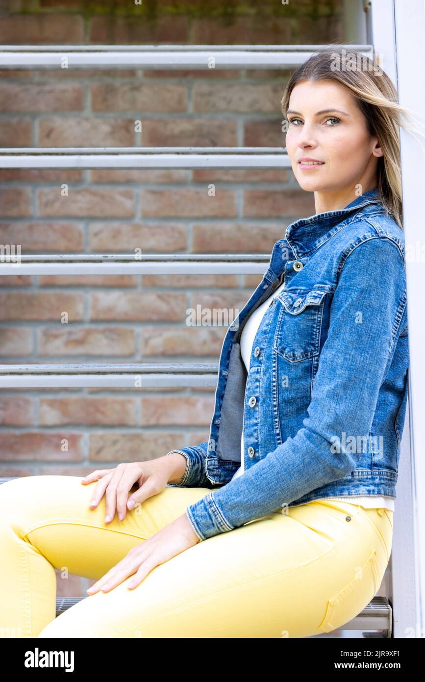 Swag and confident red haired girl in jeans and sweatshirt posing at gray  studio Stock Photo - Alamy