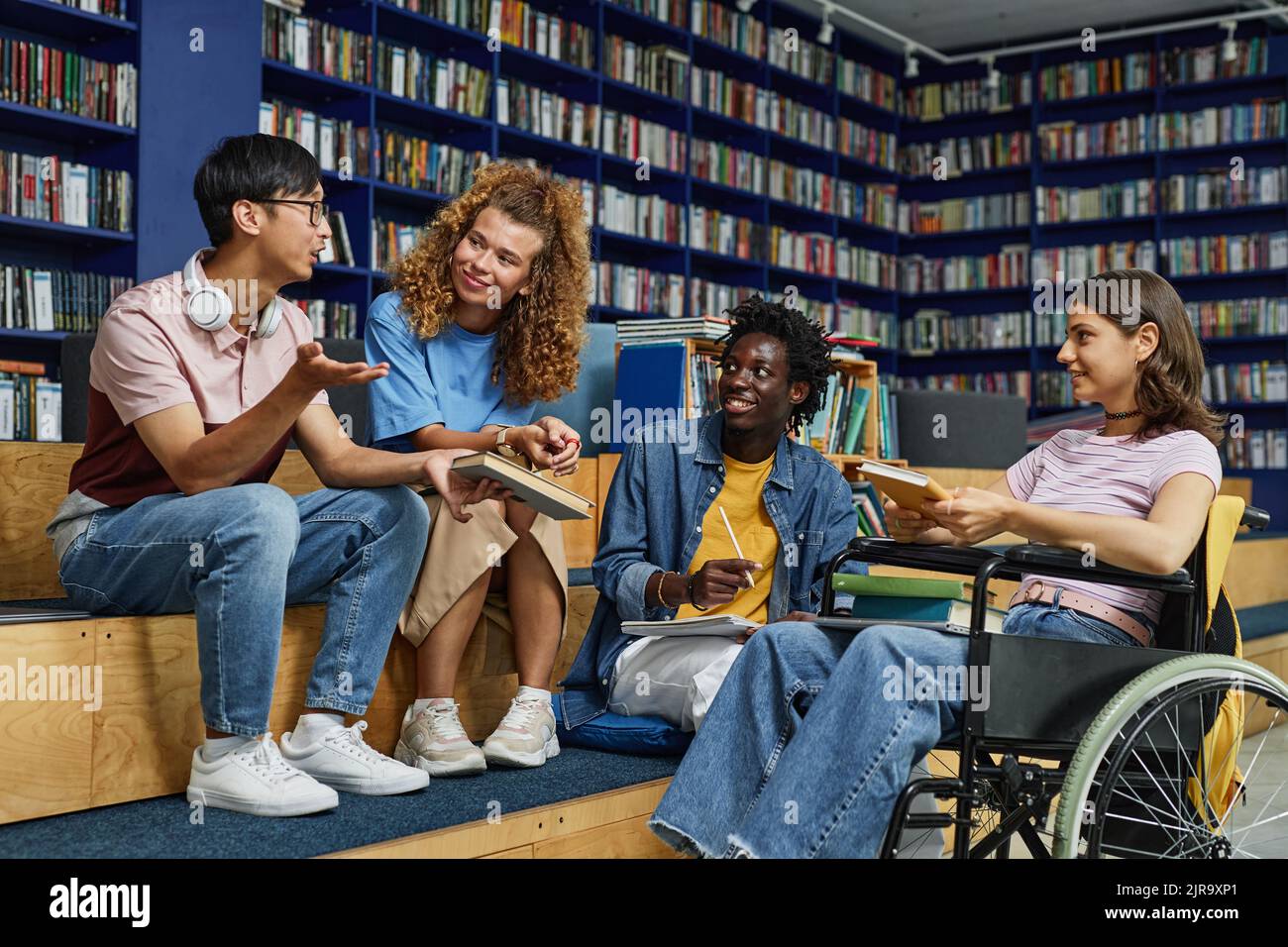 Diverse group of students in college library including young woman in