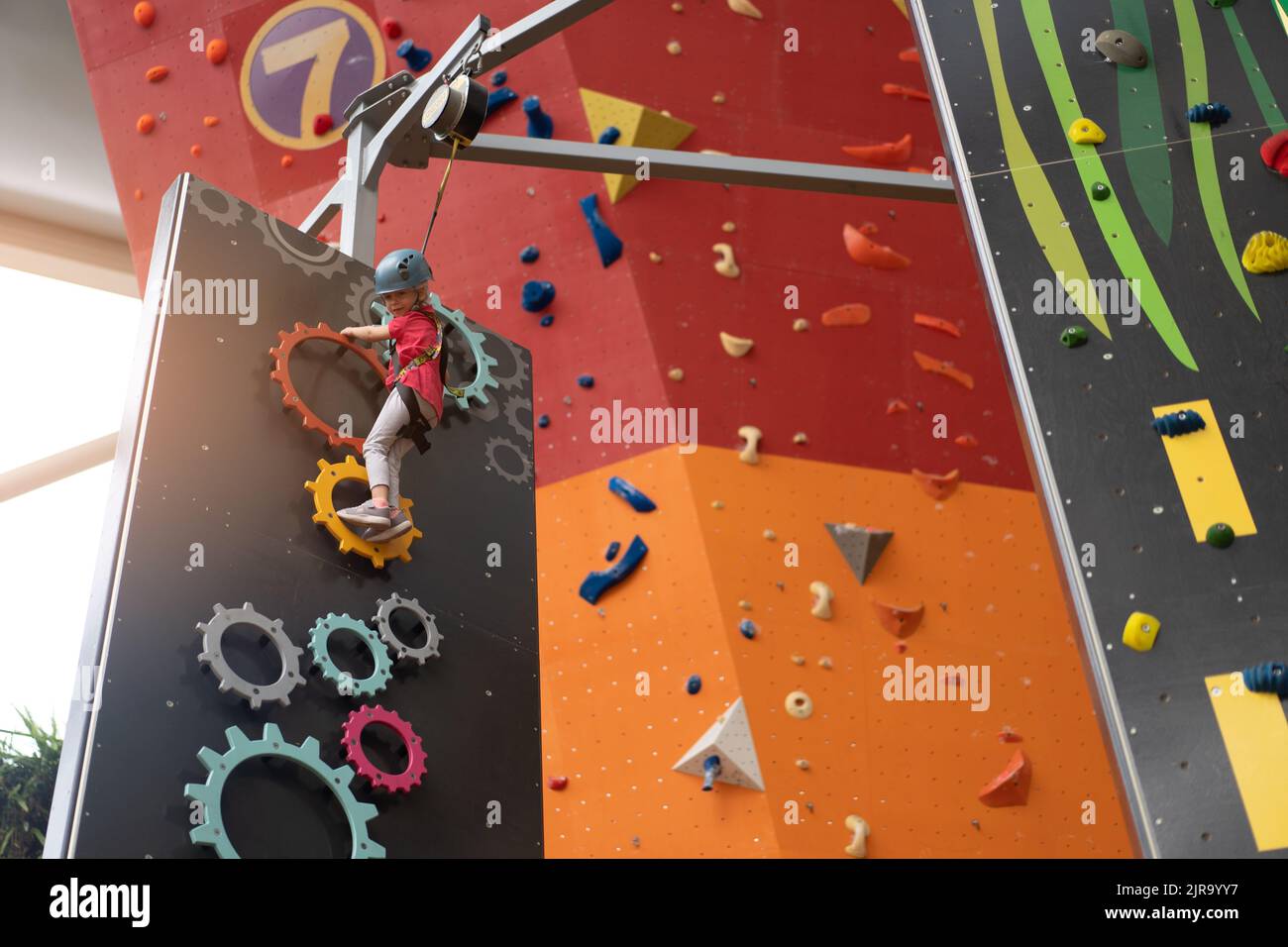Child climbing on wall in amusement centre. Climbing training for ...