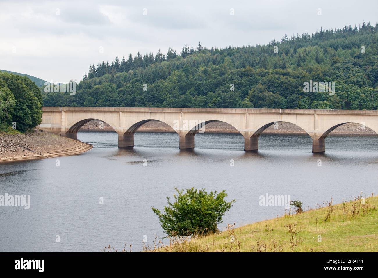 The Ladybower reservoir during the dry and drought weather in the summer of 2022.. The picture shows the view to the Ashopton bridge where the A57 crosses, the marks on the bridge showing the usual water level. Ladybower Reservoir is a large Y-shaped, artificial reservoir, the lowest of three in the Upper Derwent Valley in Derbyshire, England. Stock Photo