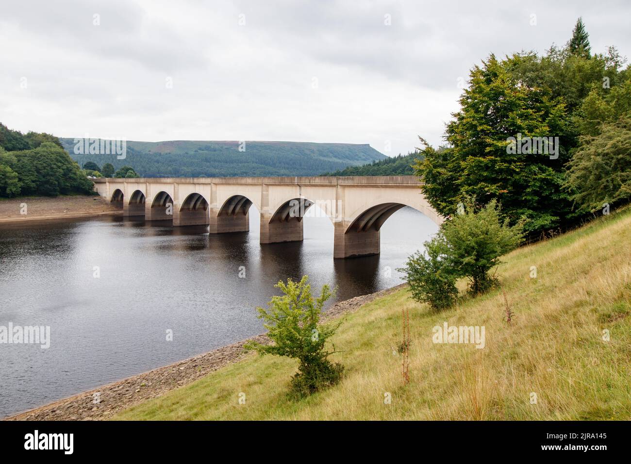 The Ashopton Bridge on the A57 that crosses over the ladybower dam in the peak district.The Ladybower reservoir during the dry and drought weather in the summer of 2022. Ladybower Reservoir is a large Y-shaped, artificial reservoir, the lowest of three in the Upper Derwent Valley in Derbyshire, England. Stock Photo