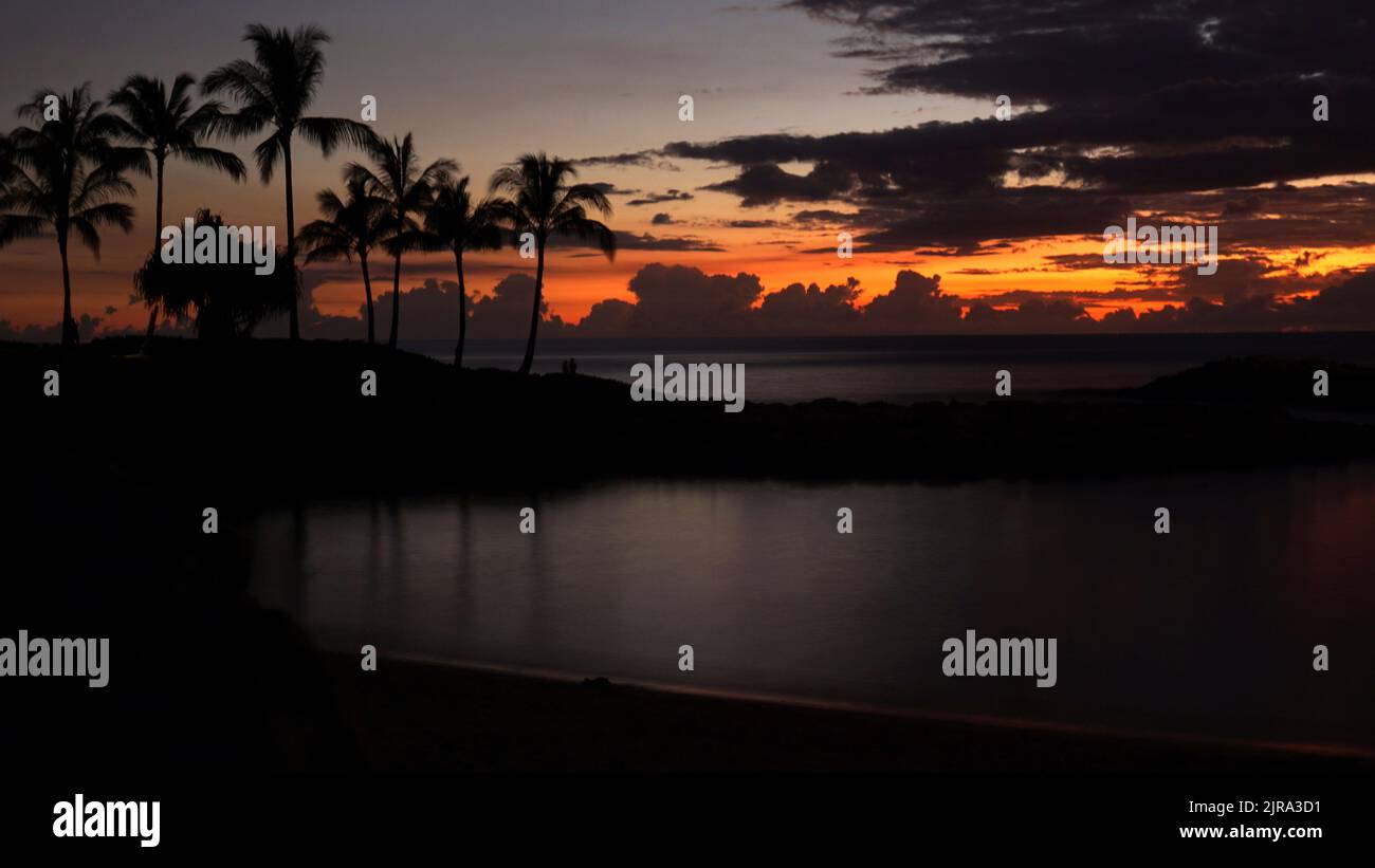 The last sliver of sunlight peaks through the clouds during sunset at Ko Olina Lagoons in the west coast of Oahu, Hawaii. Stock Photo
