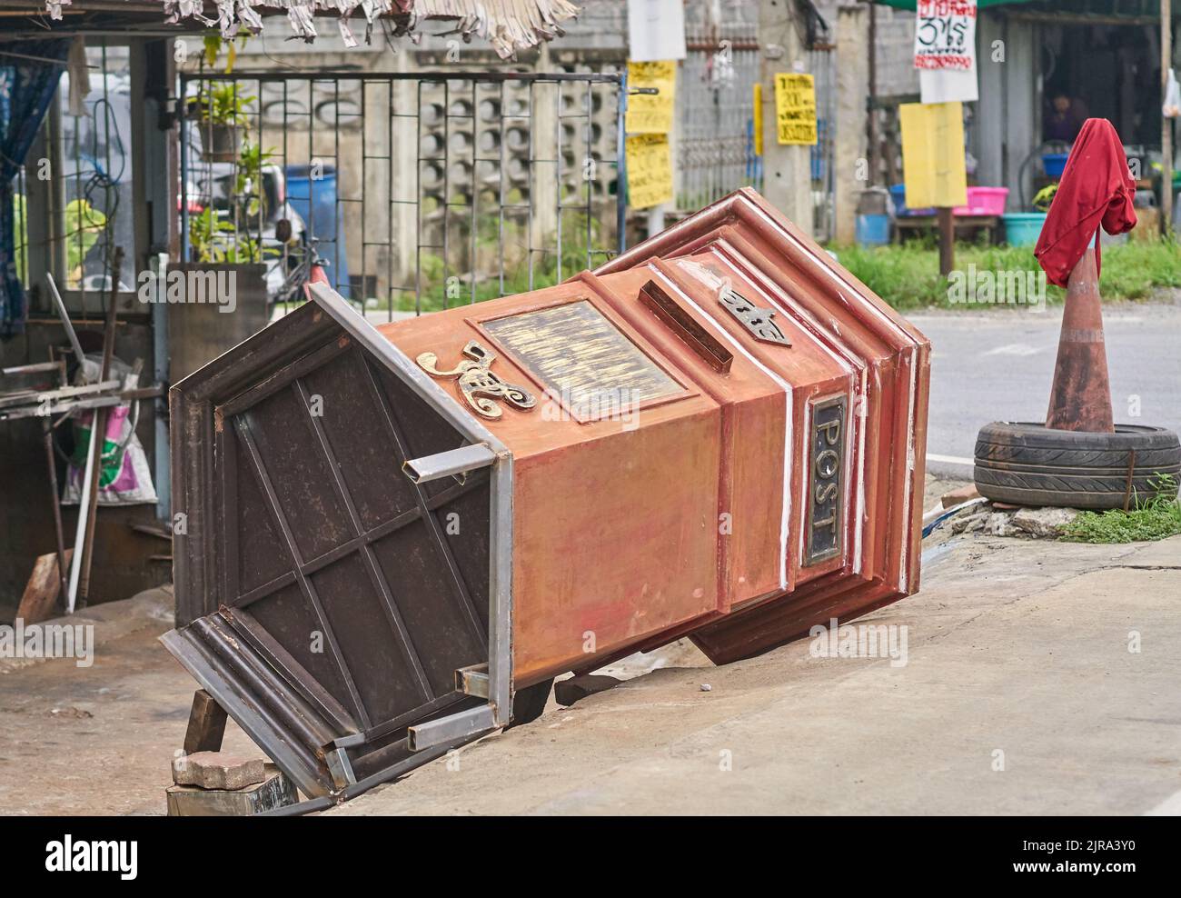 A large post office collection box toppled over on a street, in Thailand. Stock Photo