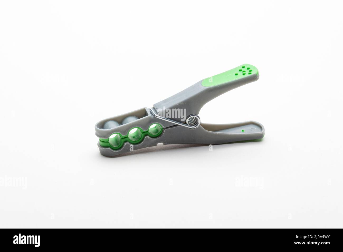 Grey plastic clothespin with green grip, isolated on white background Stock Photo