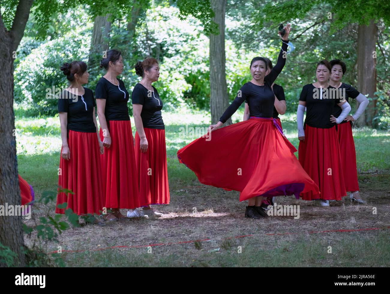 Middle age Chinese American dancers rehearse with their teacher's help in a park in Queens, New York City. Stock Photo