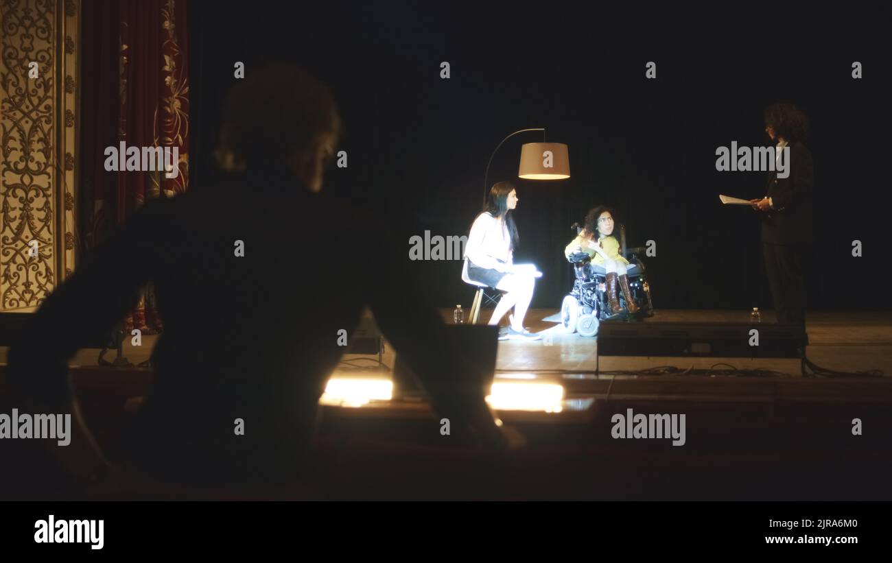 The director of the performance watching the rehearsal of the play and giving recommendations to the actors in the dark hall of the theater Stock Photo