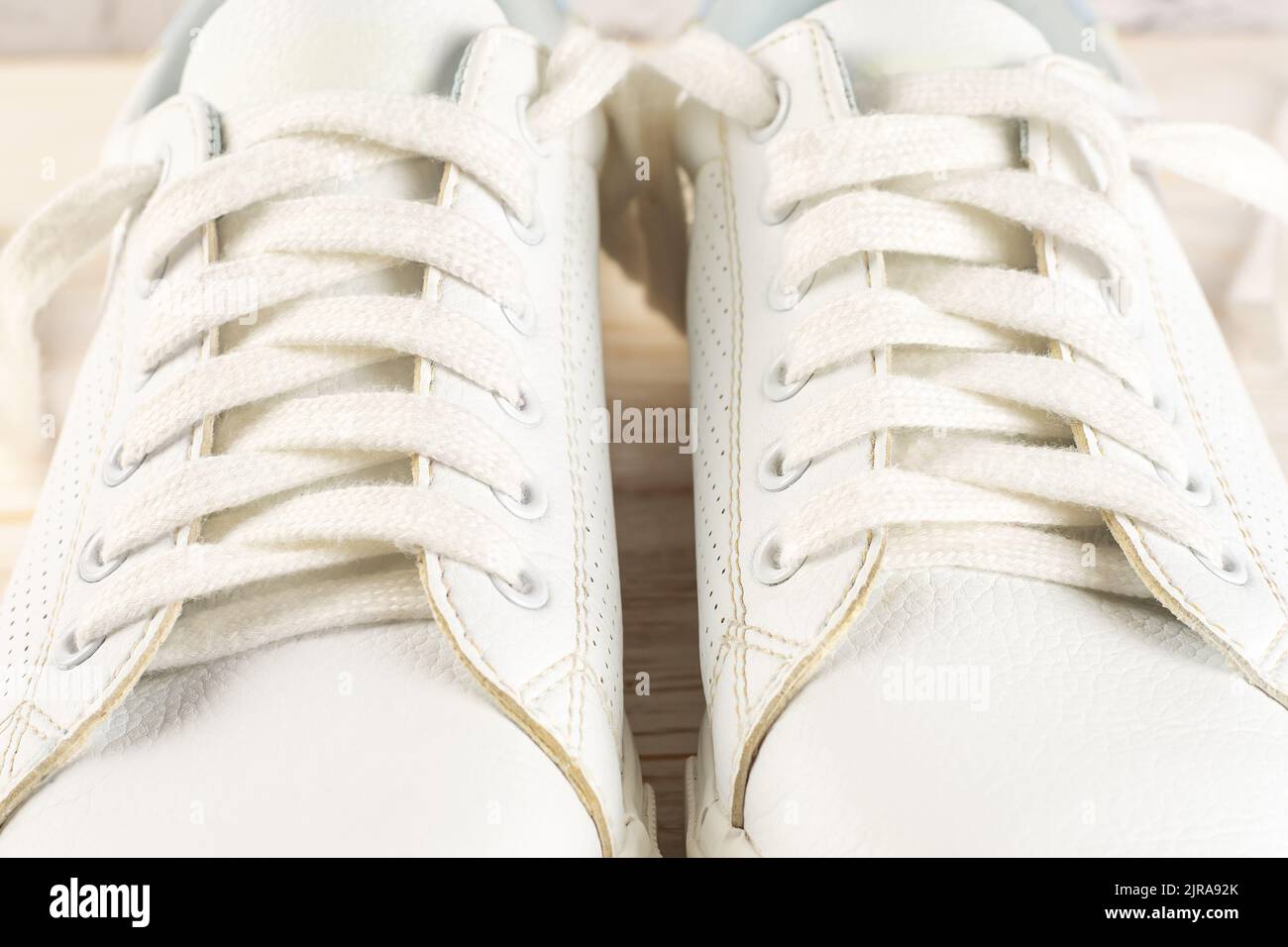 A climber lacing up a pair of climbing shoes, with a close-up shot of the lacing system