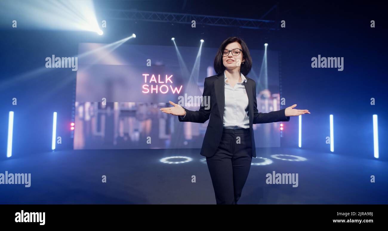 Happy presenter in a suit and glasses running onto the stage and