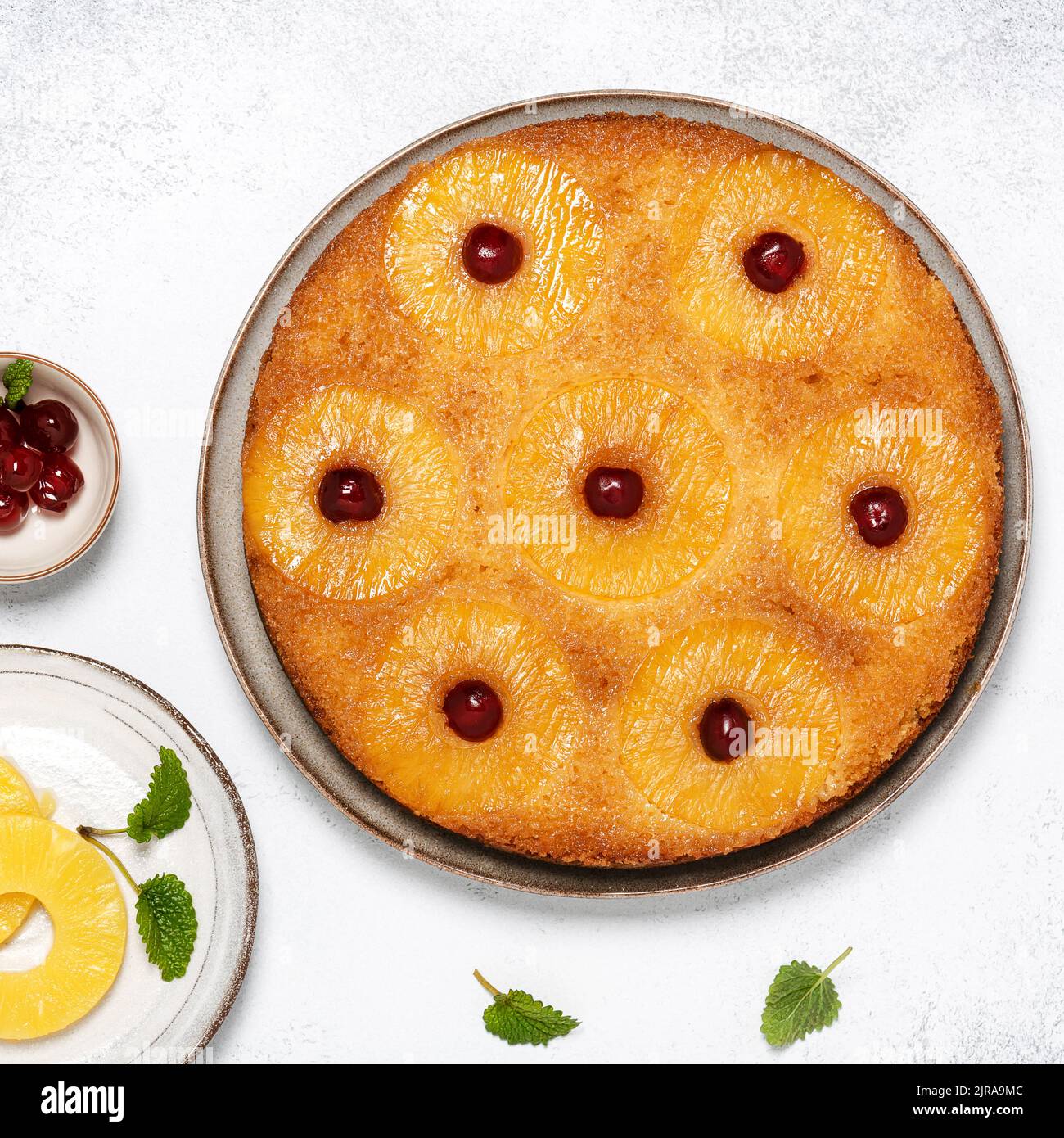 Homemade pineapple upside down cake with glace cherries. Delicious vegetarian sweet food concept. Square image. Stock Photo