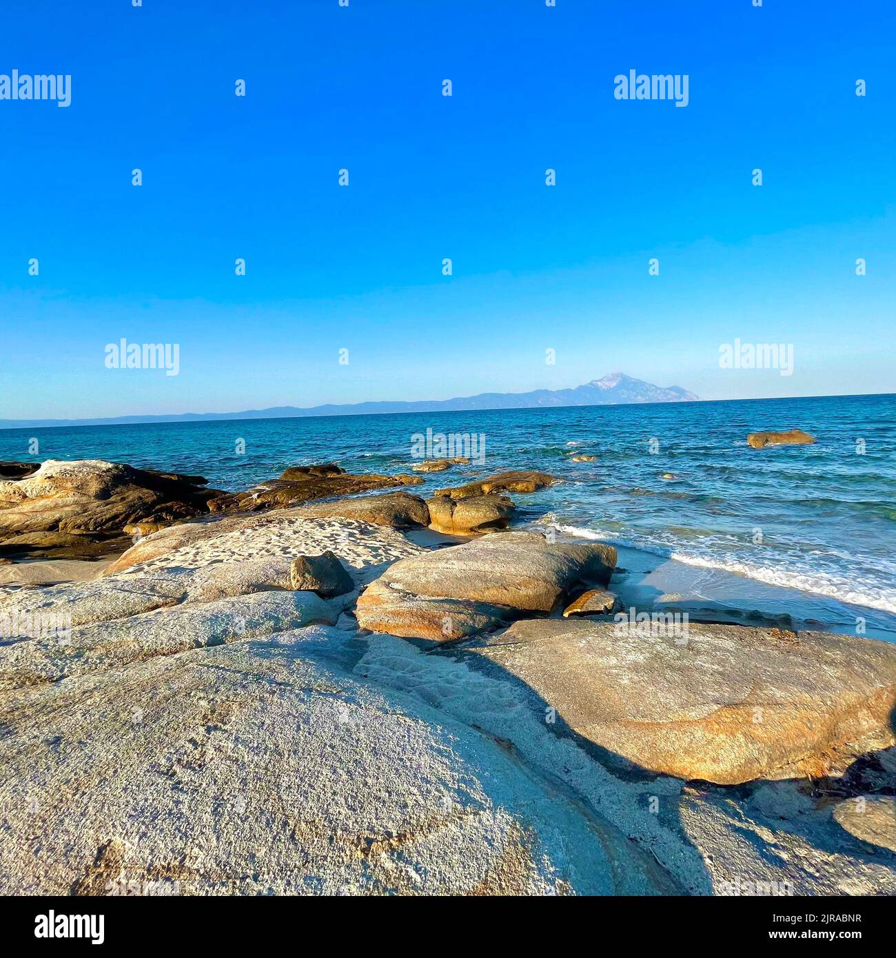 An aerial view of sea with rocky beach under blue bright sky Stock ...