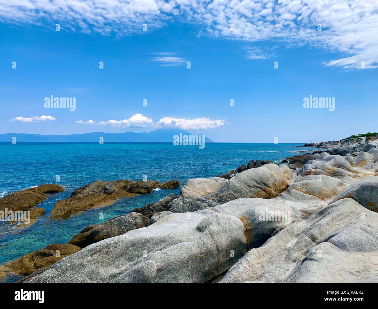 An aerial view of sea with rocky beach under blue bright sky Stock ...