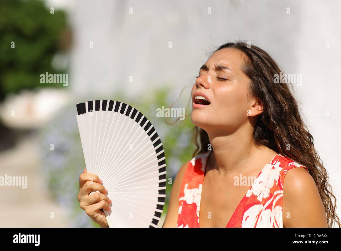 Woman suffering heat stroke in a town street on summer Stock Photo