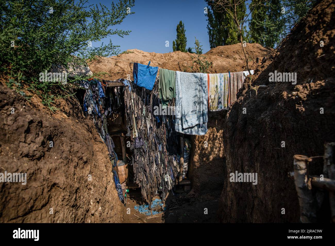 Wet clothes can be seen drying in the trenches close to the frontline at an undisclosed position in Mykolaiv Oblast, Ukraine. As Ukrainian officials have claimed partiality to recover their territory, and operating a counter-offensive in the south including Mykolaiv Oblast, to attack the Russian forces in the Kherson area. Mykolaiv oblast, with the strategic city of Ukraine located on the Southern side with access to the Black Sea and is one of the main shipbuilding centres, used to have a population of 476,101 (2021 est.), but has been undergoing heavy siege and bombardment after the full-sca Stock Photo