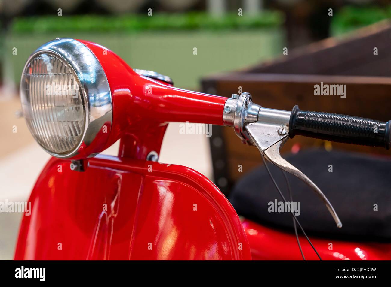 headlight, handlebar and control levers of a vintage red scooter Stock