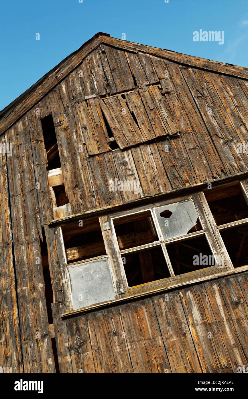 Old Rustic dilapidated shed with broken windows. Stock Photo