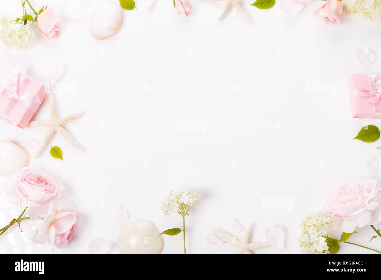 Elegant gift box and beautiful pink rose flowers on white background, flat lay. Space for text. Stock Photo