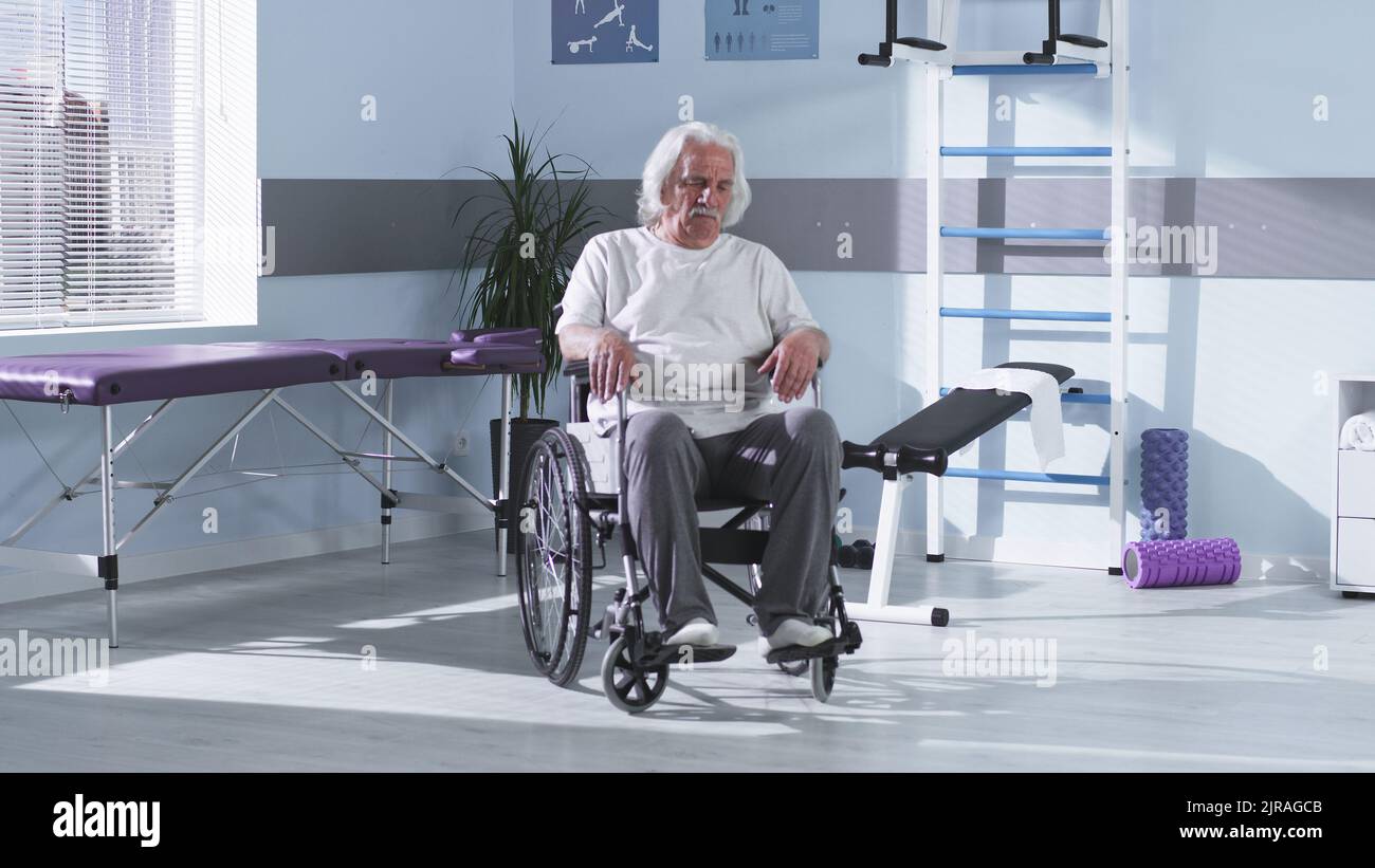 Elderly male patient with disability sitting on wheelchair in