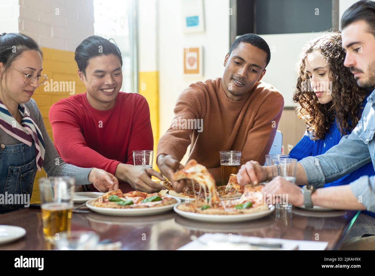 smiling-friends-eating-pizza-at-modern-pizzeria-restaurant-friendship