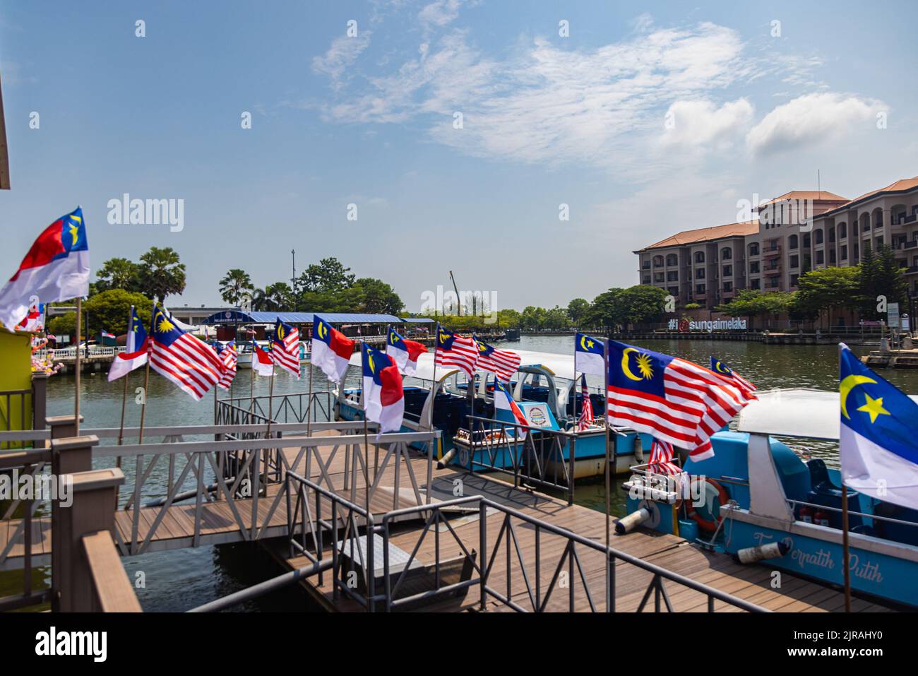 Malacca, Malaysia - August 10, 2022: Pier of the Melaka River Park and Cruise, decorated with malaysian flags for the national day of Malaysia. Touris Stock Photo