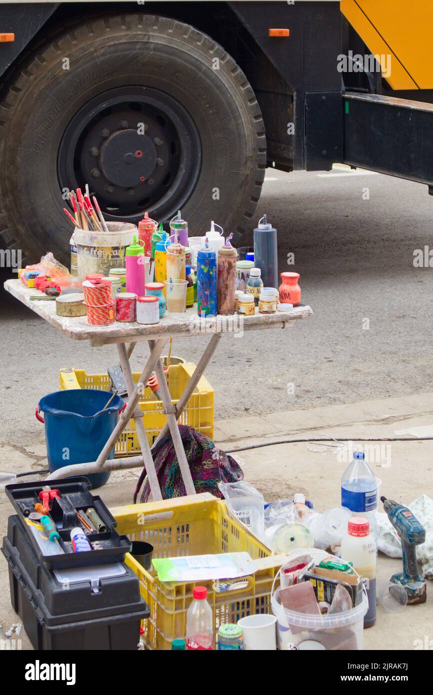 Close-up of a table full of paint cans on which a street artist painter works Stock Photo
