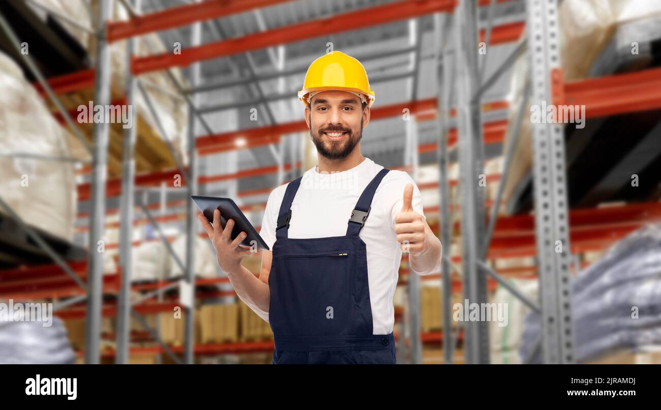 loader with tablet pc shows thumbs up at warehouse Stock Photo