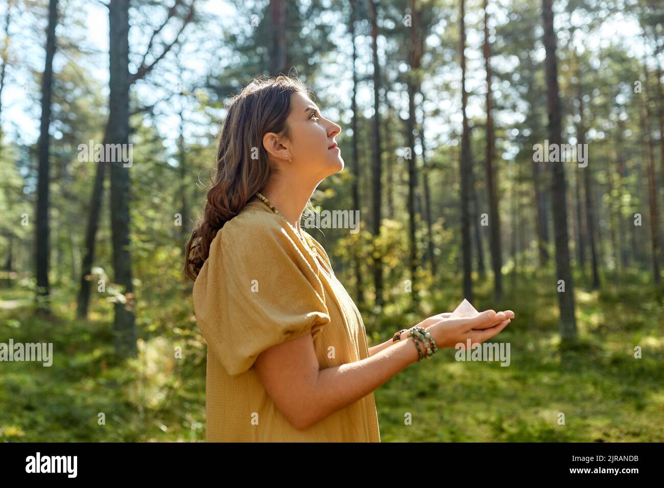 young woman or witch holding pyramid in forest Stock Photo