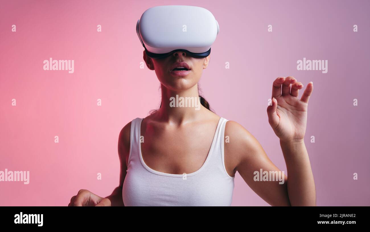 Woman entering a virtual reality game in a studio. Young woman looking