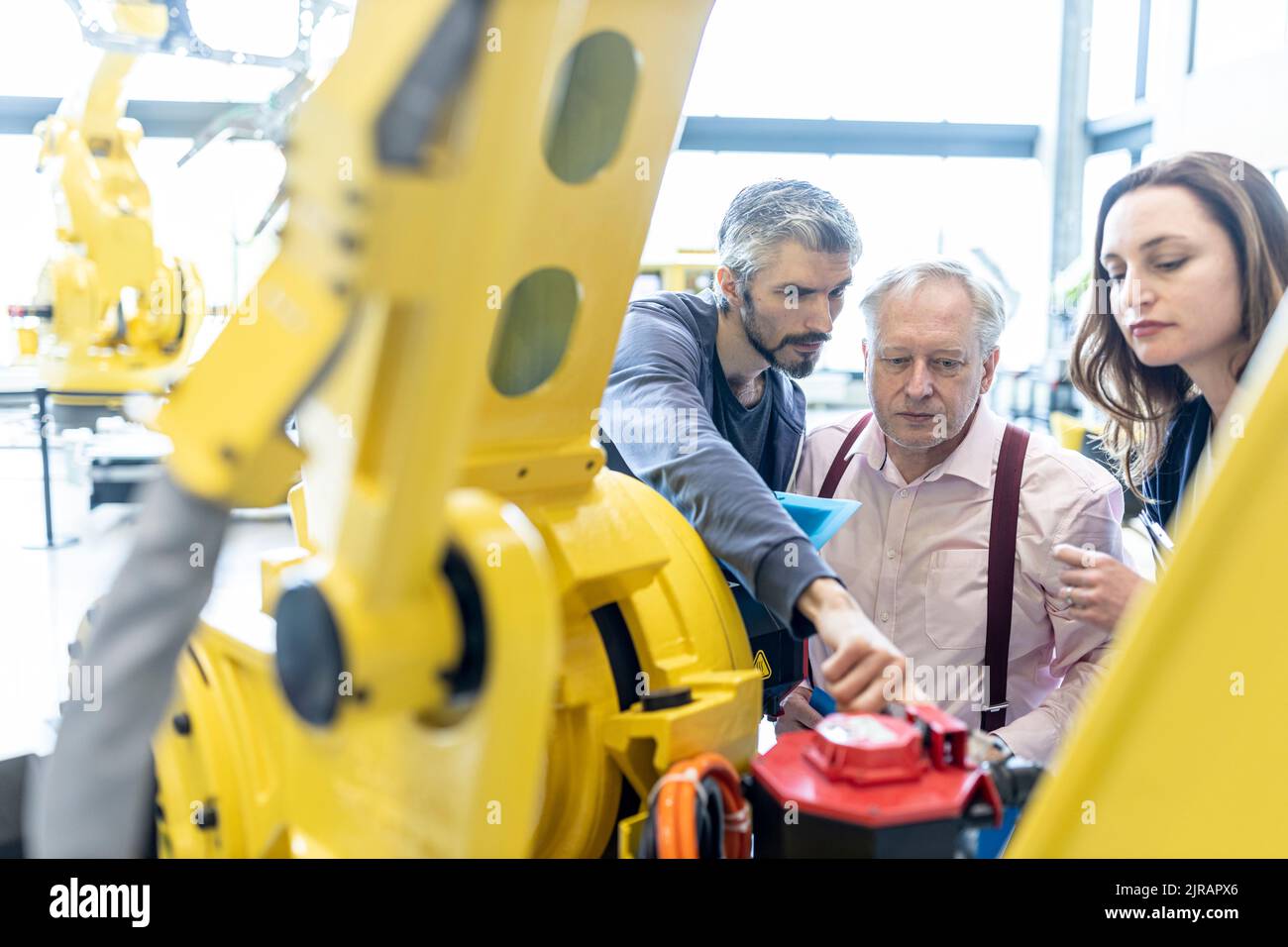 Technicians examining industrial robot in factory Stock Photo Alamy