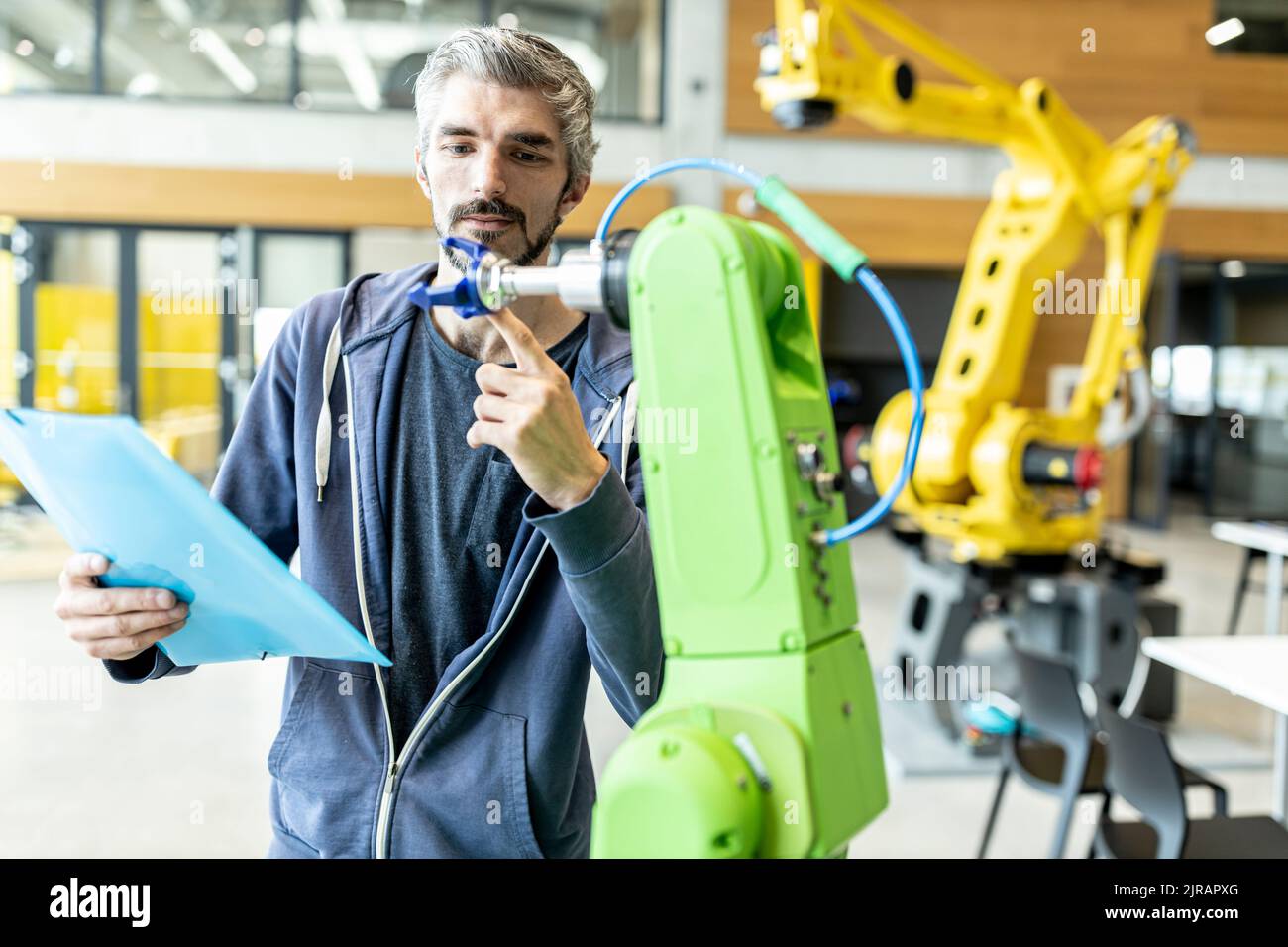Technician inspecting industrial robot in factory Stock Photo Alamy