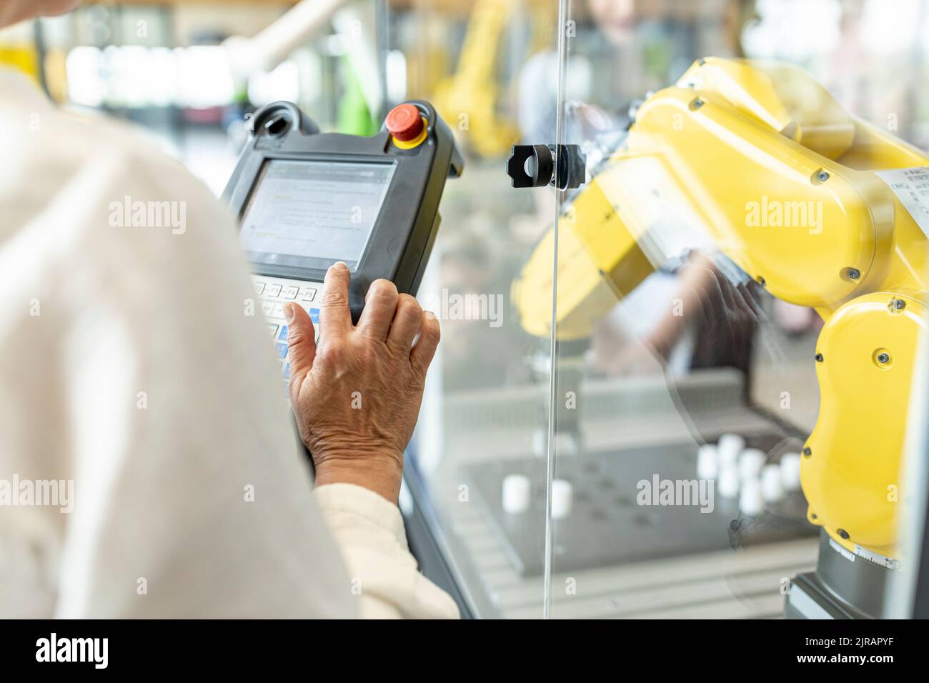 Woman in factory using control of industrial robot Stock Photo
