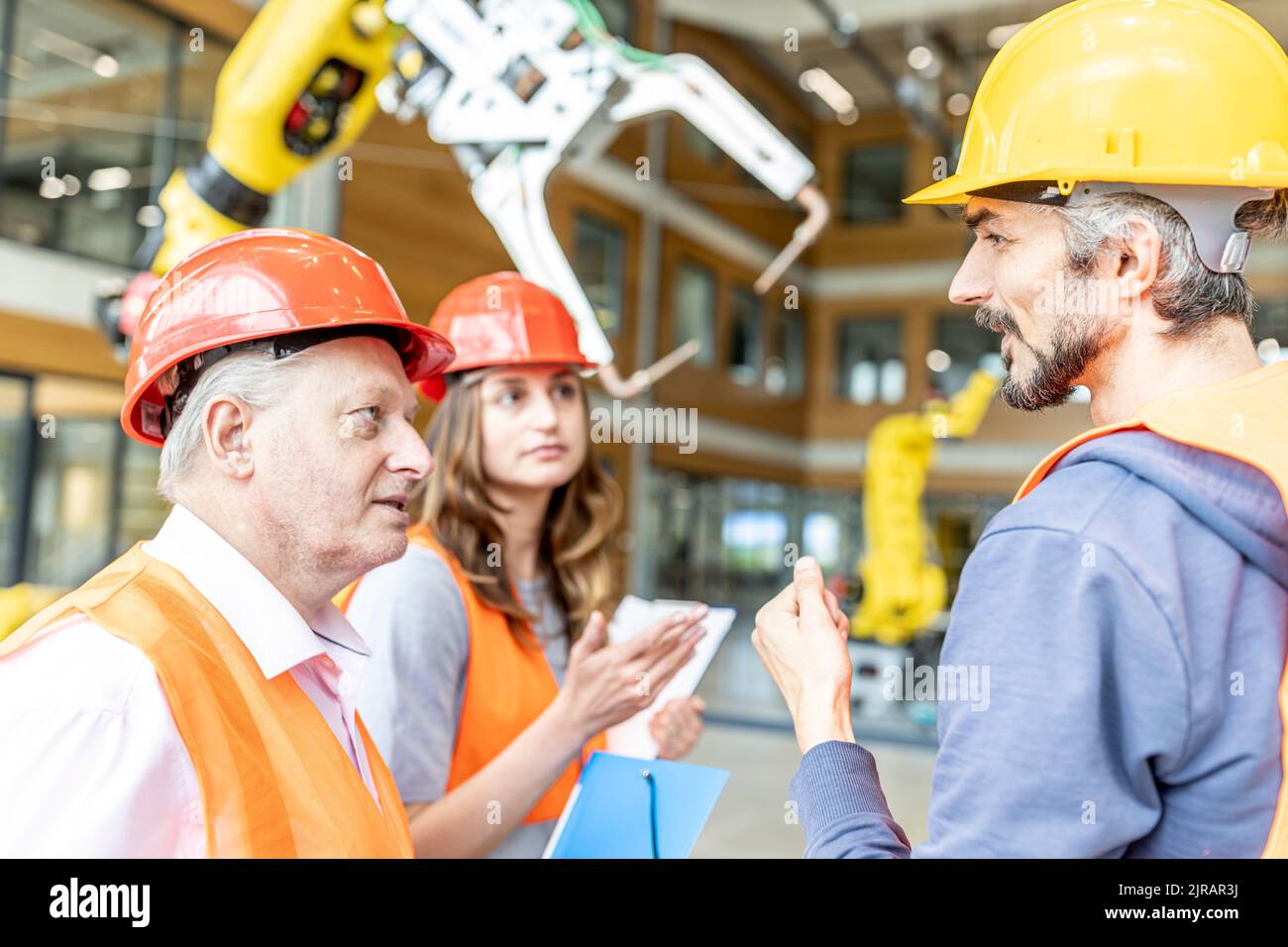 Senior colleague in work wear having meeting with skilled workers Stock Photo